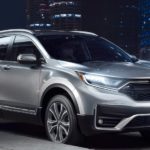 A silver 2021 Honda CR-V Touring is shown parked on a city street at night after leaving a car dealer.