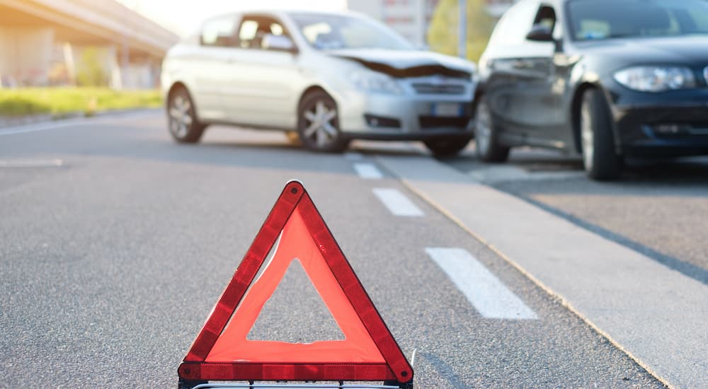 A warning cone is placed in front of a car collision.