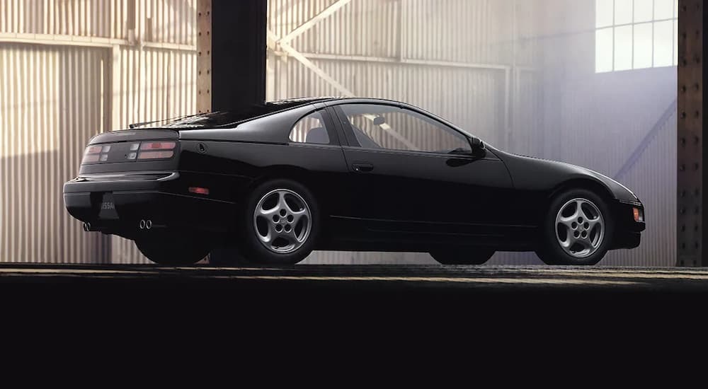 A black 1993 Nissan 300zx is shown from the side at an angle in a warehouse after leaving a used Nissan dealership.