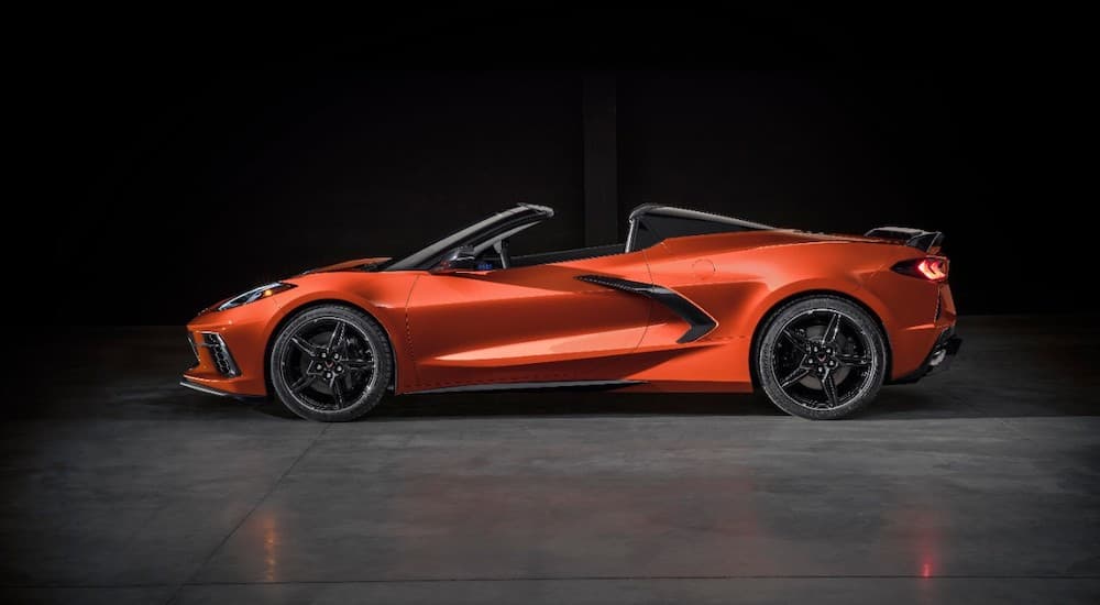 An orange 2022 Chevy Corvette is shown from the side against a black background.