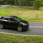 A black 2022 Buick Encore is shown from the side while rounding a corner during a 2022 Buick Encore GX vs 2022 Ford Bronco Sport comparison.