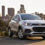 A silver 2022 Chevy Trax is shown from a front angle parked on a city hill during a 2022 Chevy Trax vs 2022 Kia Soul comparison.