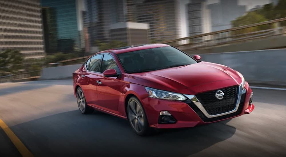 A red 2021 Nissan Altima is shown from the front at an angle after leaving a used Nissan Altima dealer.
