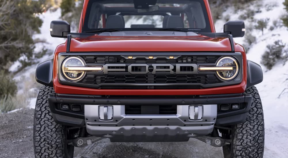 A red 2022 Ford Bronco is shown from the front parked in the mountains.