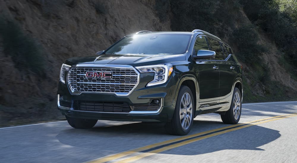 A black 2022 GMC Terrain is shown from the front driving on an open road.