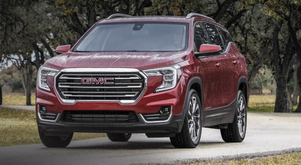 A red 2022 GMC Terrain vs 2022 Honda CR-V is shown from the front is shown driving on an open road during a 2022 GMC Terrain vs 2022 Honda CR-V vs 2022 Honda CR-V comparison.
