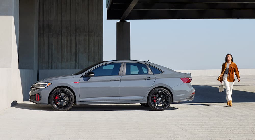 A grey 2022 Jetta GLI is shown from the side while parked on top of a parking garage during a 2022 Volkswagen Jetta vs 2022 Honda Civic comparison.