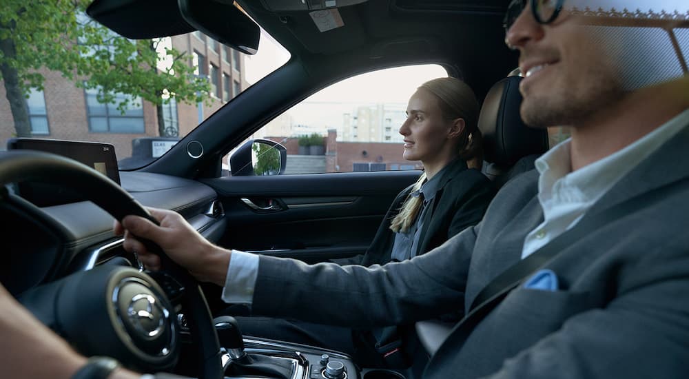 A person is shown from the driver side while driving a 2022 Mazda CX-5.