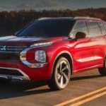 A red 2022 Mitsubishi Outlander is shown from the front going down the road after leaving a Mitsubishi dealer in Edmonton.