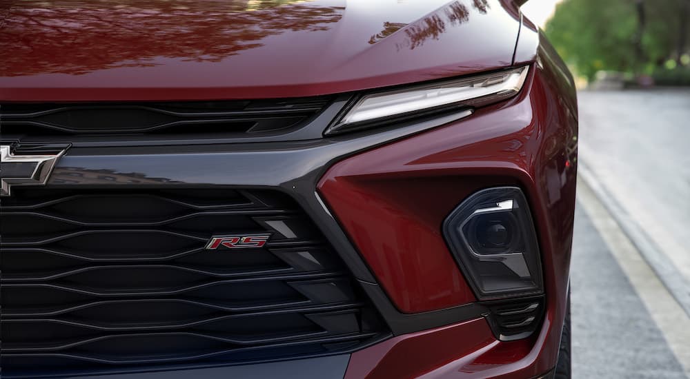 A close up shows the driver side headlight on a red 2023 Chevy Blazer RS.