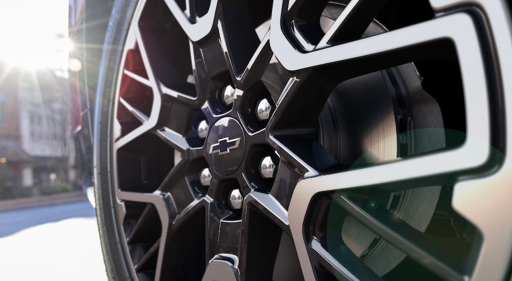 A close up shows the the black and silver wheel on a red 2023 Chevy Blazer RS.