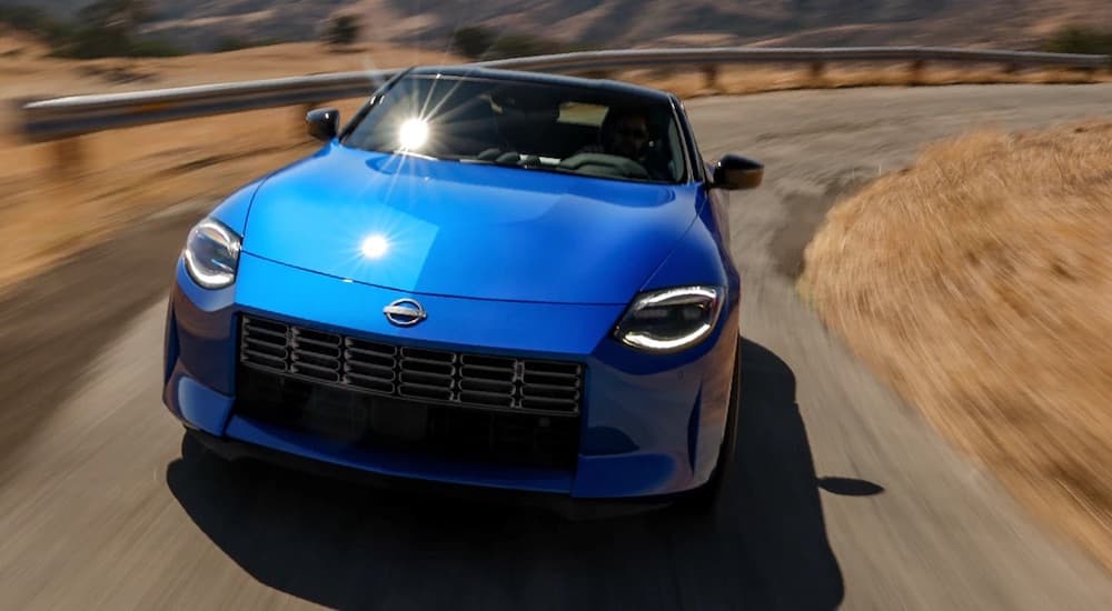 A blue 2023 Nissan Z is shown from the front while rounding a corner.