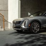 A grey 2024 Cadillac Lyriq leaving a parking garage after visiting a Cadillac dealer.