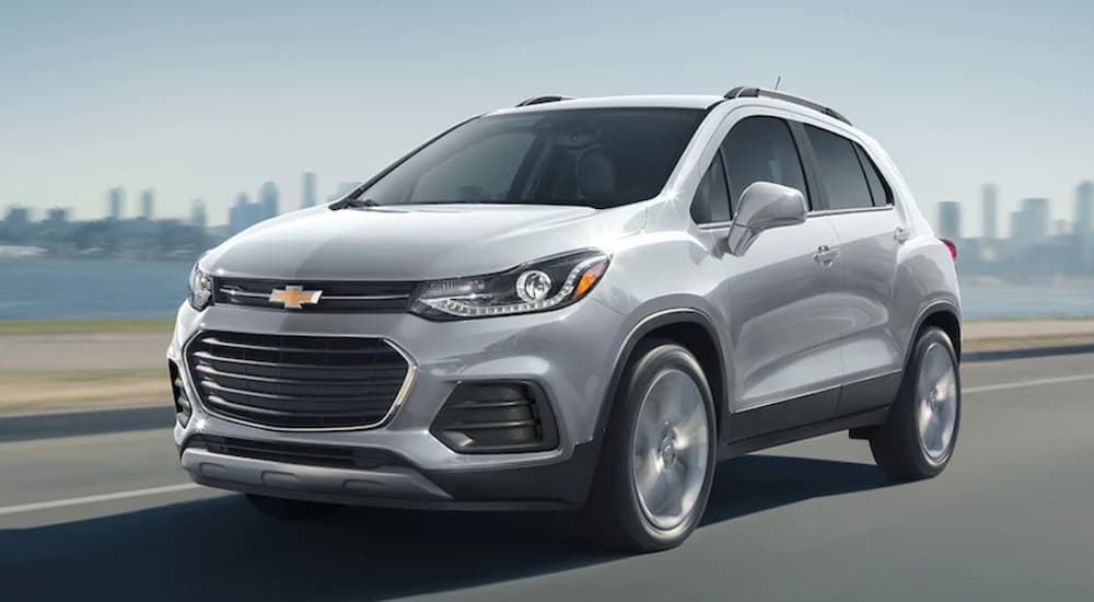 A silver 2022 Chevy Trax is shown from the front at an angle while driving on a coastal road.