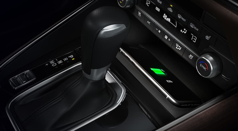 A phone, shifter, and HVAC controls are shown in a 2022 Mazda CX-9.