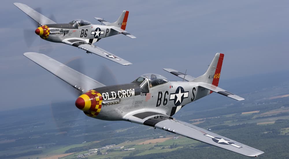 Two P51 Mustangs are shown from the front while flying in formation.