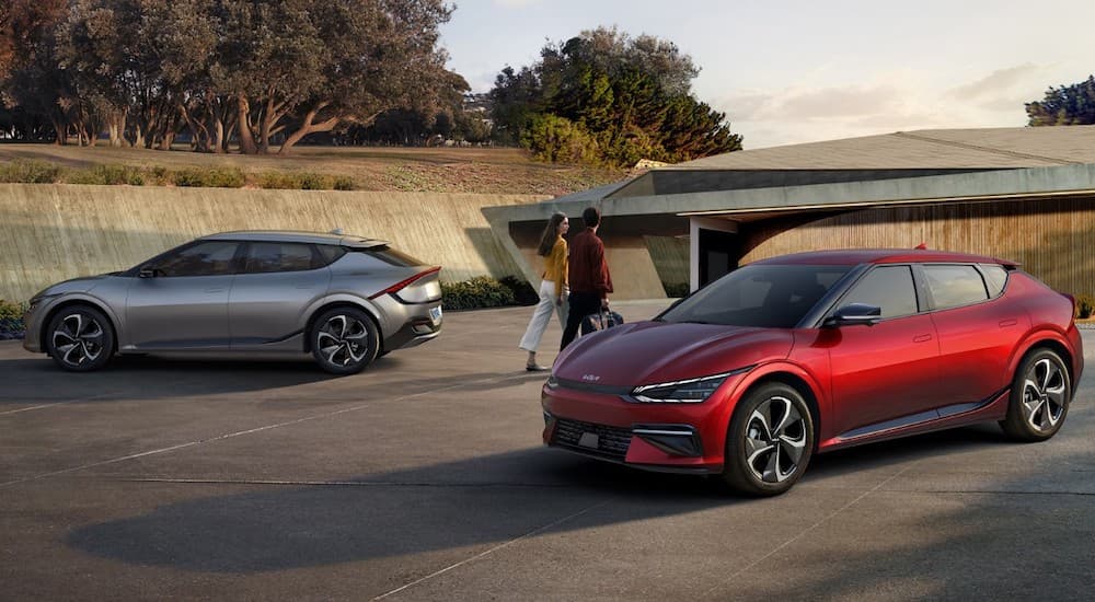 A silver and a red 2022 Kia EV6 are shown from the side after leaving a Kia dealer near you.