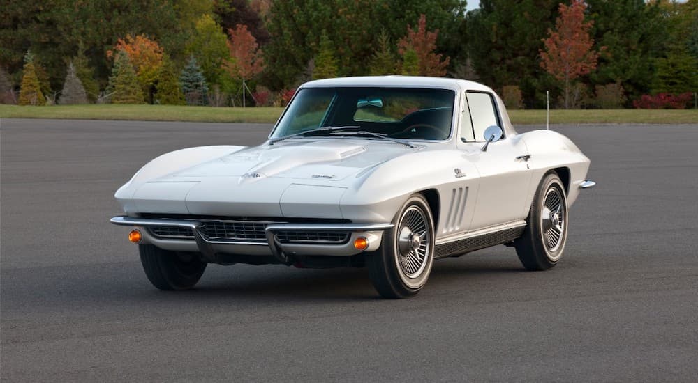 A white 1966 Chevrolet Corvette Stingray is shown from the front at an angle parking in an open lot.