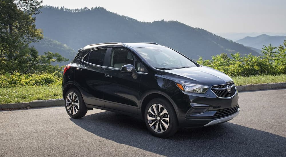 A black 2022 Buick Encore is shown from the side parked overlooking a mountain during a 2022 Buick Encore vs 2022 Ford EcoSport comparison.