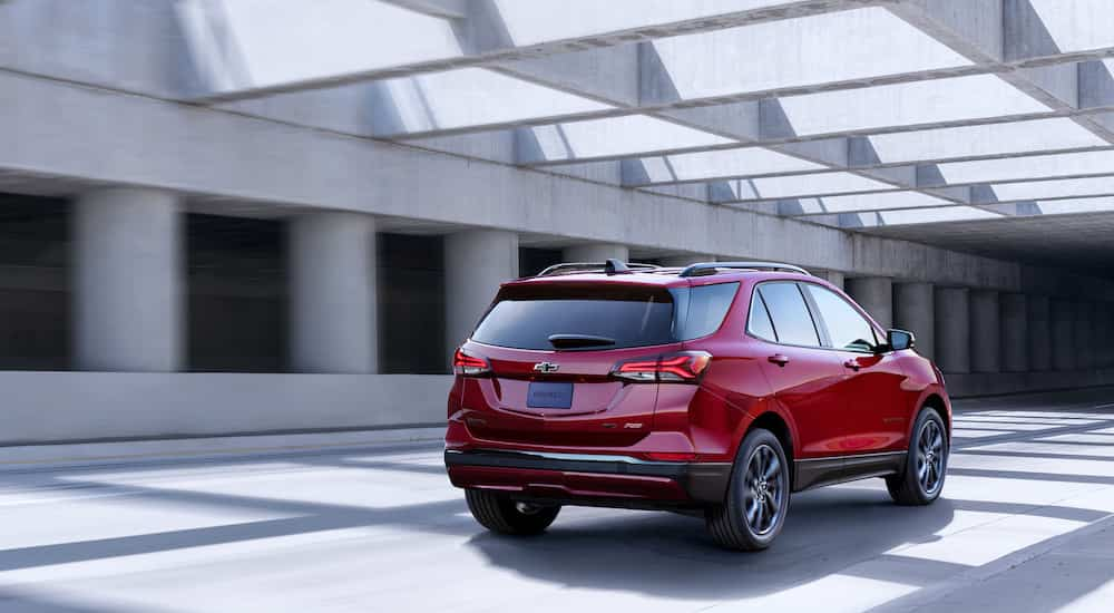 A red 2022 Chevy Equinox RS is shown from the rear while it drives down the highway.