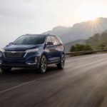 A blue 2022 Chevy Equinox is shown from the front at an angle while driving down the road.