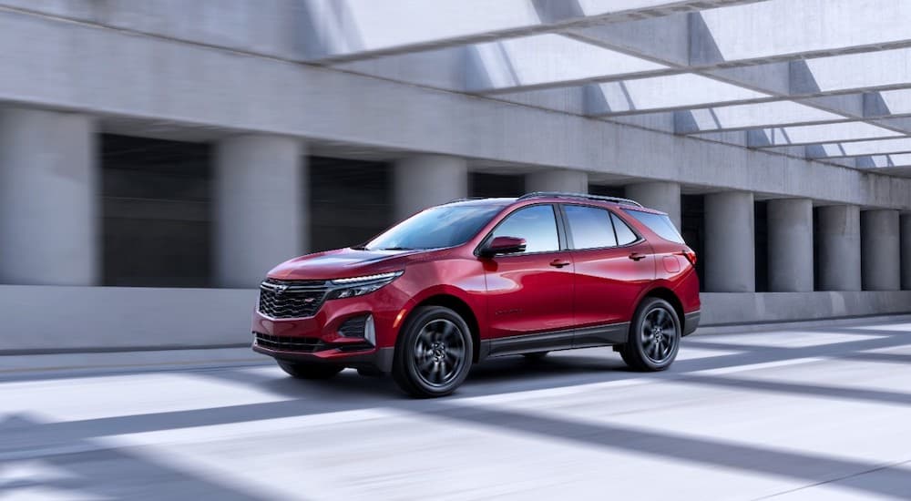 A red 2022 Chevy Equinox RS is shown from the front at an angle while driving down the highway.