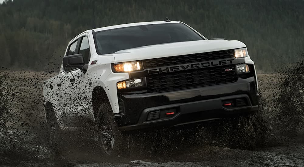 A white 2022 Chevy Silverado 1500 is shown from the front off-roading during a 2022 Chevy Silverado 1500 vs 2022 Nissan Titan comparison. 