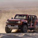 A red 2022 Ford Bronco Raptor is shown from the front at an angle while sliding.