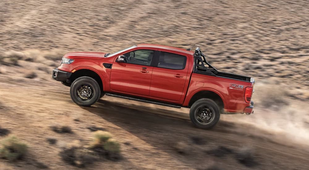 A red 2022 Ford Ranger is shown from the side off-roading in a desert.