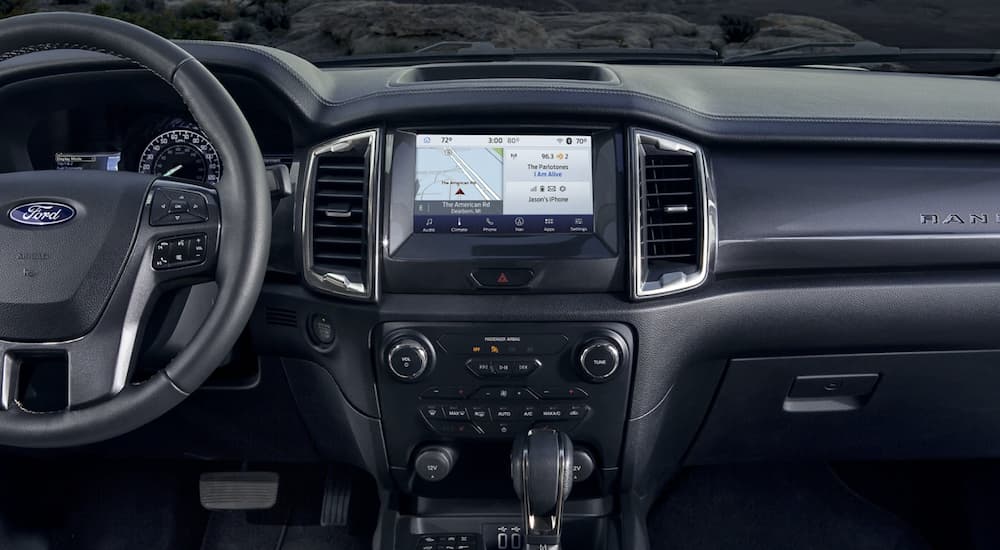 The black interior of a 2022 Ford Ranger shows the steering wheel and infotainment screen.