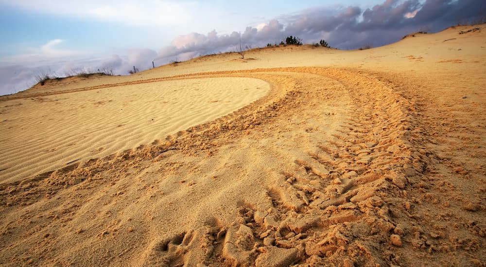 A tire track is shown in a desert.