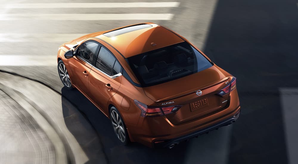 An orange 2022 Nissan Altima is shown from above rounding a corner.