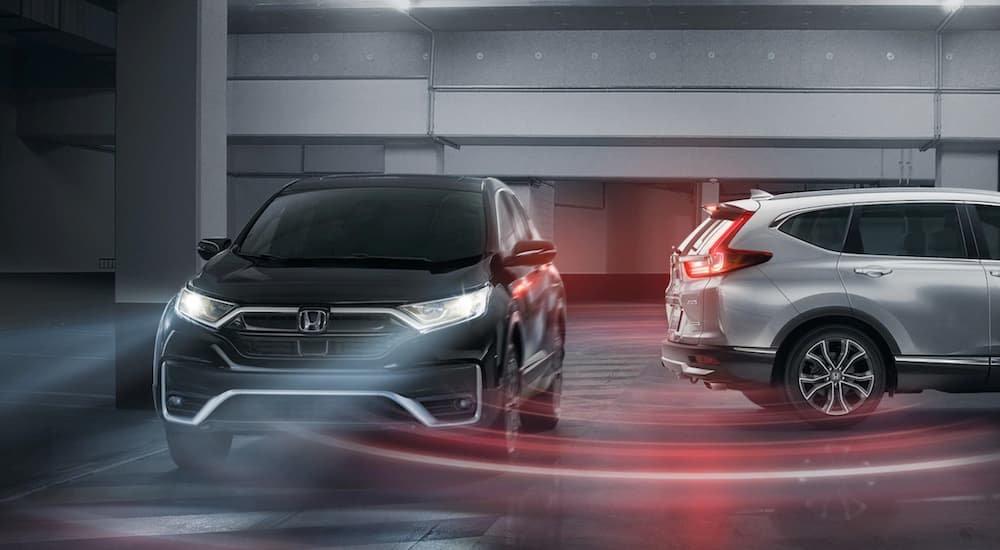 A black 2022 Honda CR-V Touring is shown driving inside a parked garage during a 2022 Honda CR-V vs 2022 Toyota RAV4 comparison.