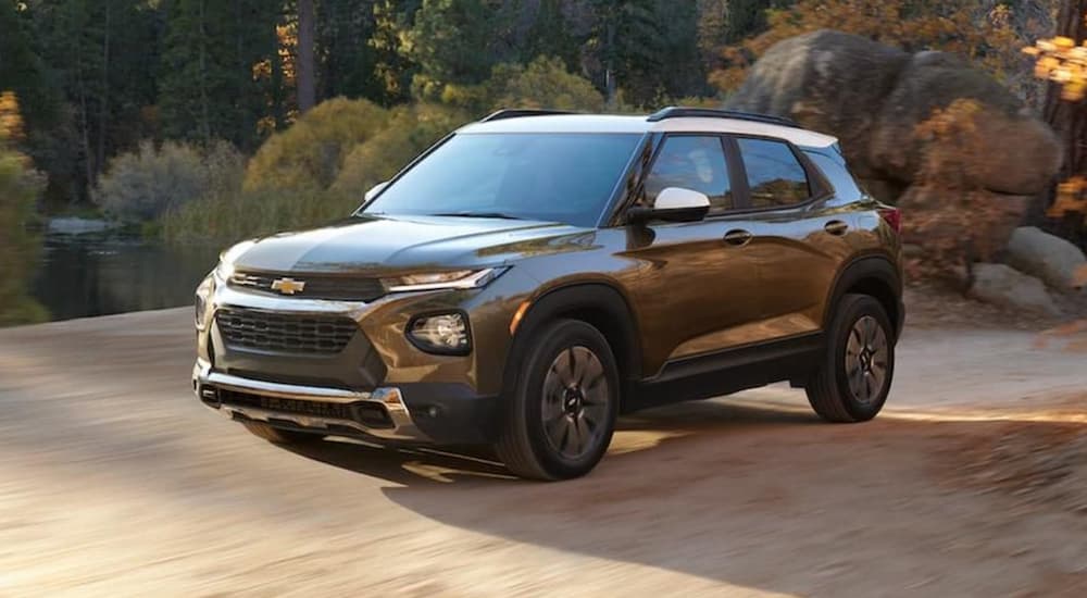 A gold 2022 Chevy Trailblazer is shown from the front driving on a dirt road.