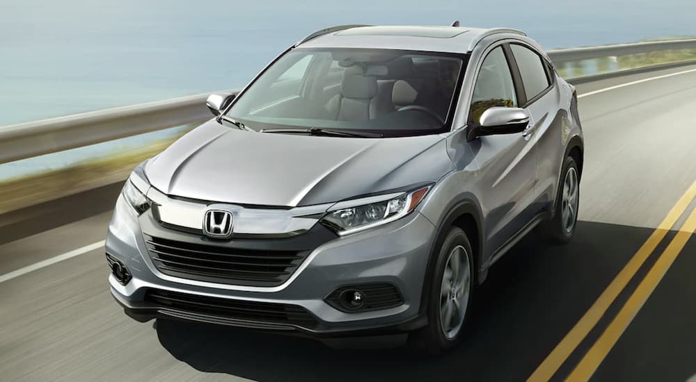 A grey 2022 Honda HR-V EX-L is shown from the front driving on an open road during a 2022 Honda HR-V vs 2022 Chevy Trailblazer comparison.