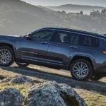 A black 2022 Jeep Grand Cherokee is shown from the side parked in the mountains.