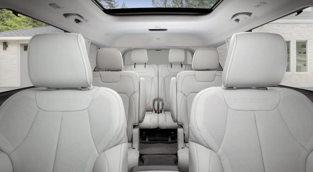 The white interior of a 2022 Jeep Grand Cherokee shows three rows of seating.