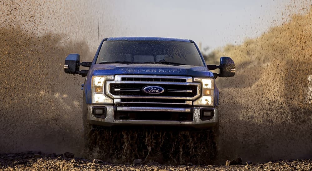 A black 2022 Silverado 3500 HD is shown from the front driving off-roading in a dirt field during a 2022 Silverado 3500 HD vs 2022 Ford F-350 comparison.