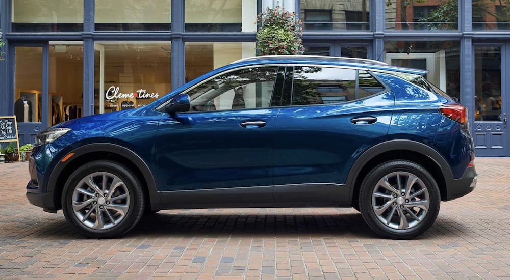 A blue 2022 Buick Encore GX is shown from the side parked in front of a building.