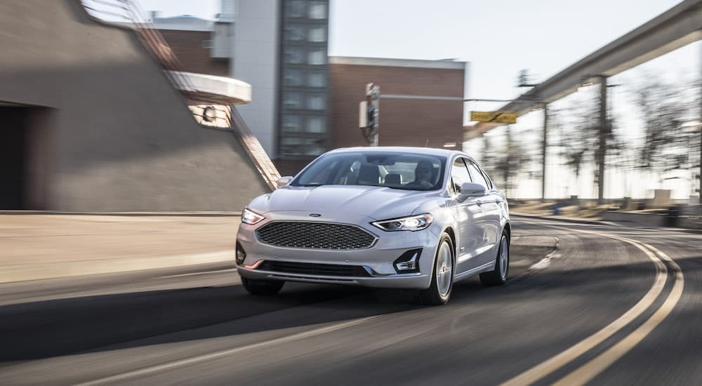 A silver 2020 Ford Fusion is shown from the front at an angle while rounding a corner.