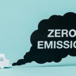 A small toy white car is shown next to an exhaust cloud that says 'zero emission.'