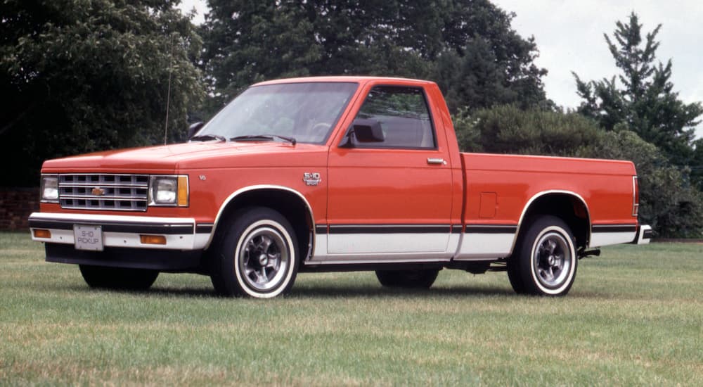 A red and white 1982 Chevy S-10 is shown parked on grass.
