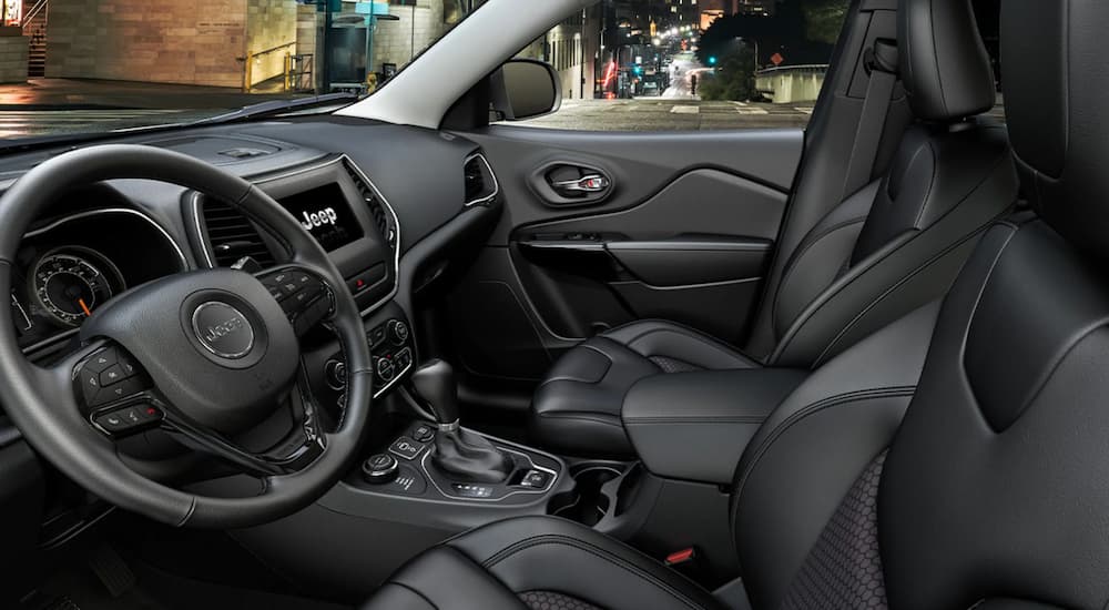 The interior of a 2022 Jeep Cherokee is shown from the driver's door opening.