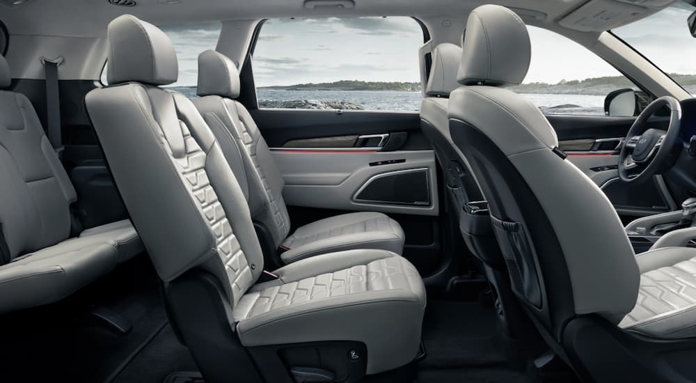 The grey interior of a 2022 Kia Telluride shows three rows of seating.