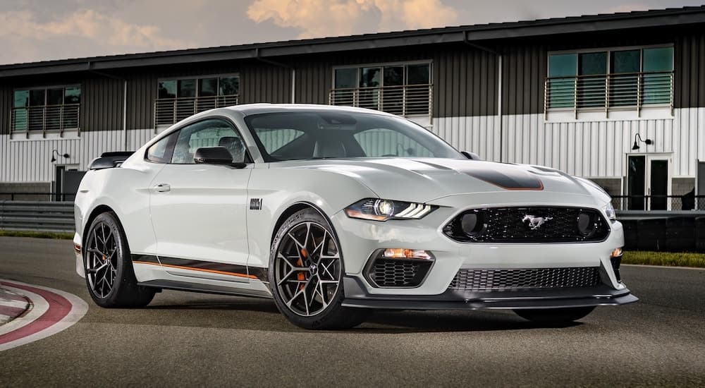 A grey 2022 Ford Mustang Mach 1 is shown from the front while parked on a racetrack.