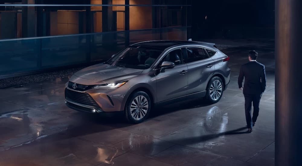 A grey 2022 Toyota Venza is shown from the front at an angle while the owner approaches at night.