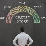 A chalk board shows a credit score meeter and a person looking up at it.
