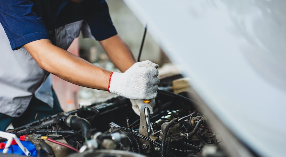 A mechanic is shown preforming car maintenance.