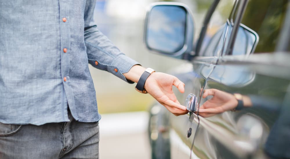 A person is shown opening a car door.