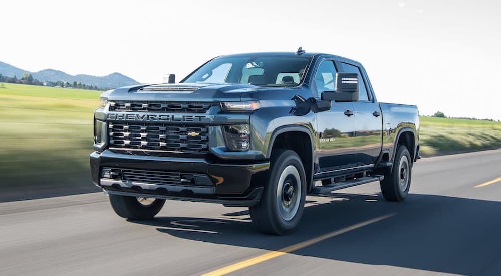 A black 2020 Chevy Silverado 2500 is shown from the front driving on an open road.